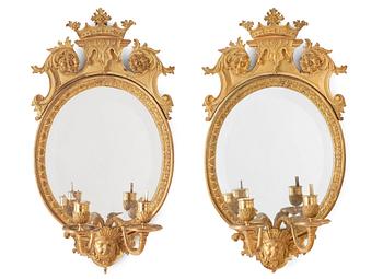 A pair of late Baroque-style circa 1900 gilt bronze two-light girandole mirrors.