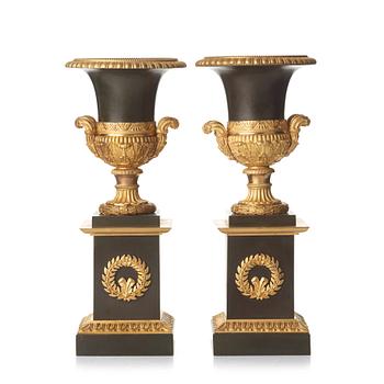 A pair of French Empire early 19th century gilt and patinated bronze urns.