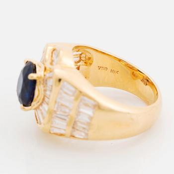 An 18K gold Junod ring set with a facted sapphire and tapered baguette-cut diamonds.