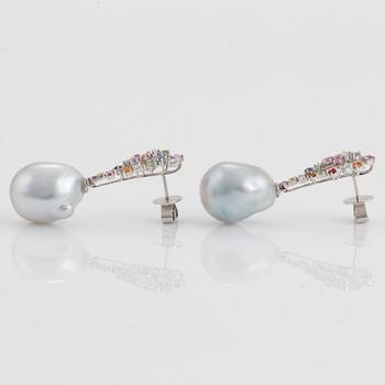 A pair of cultured drop shaped South Sea pearl earrings set with sapphires.