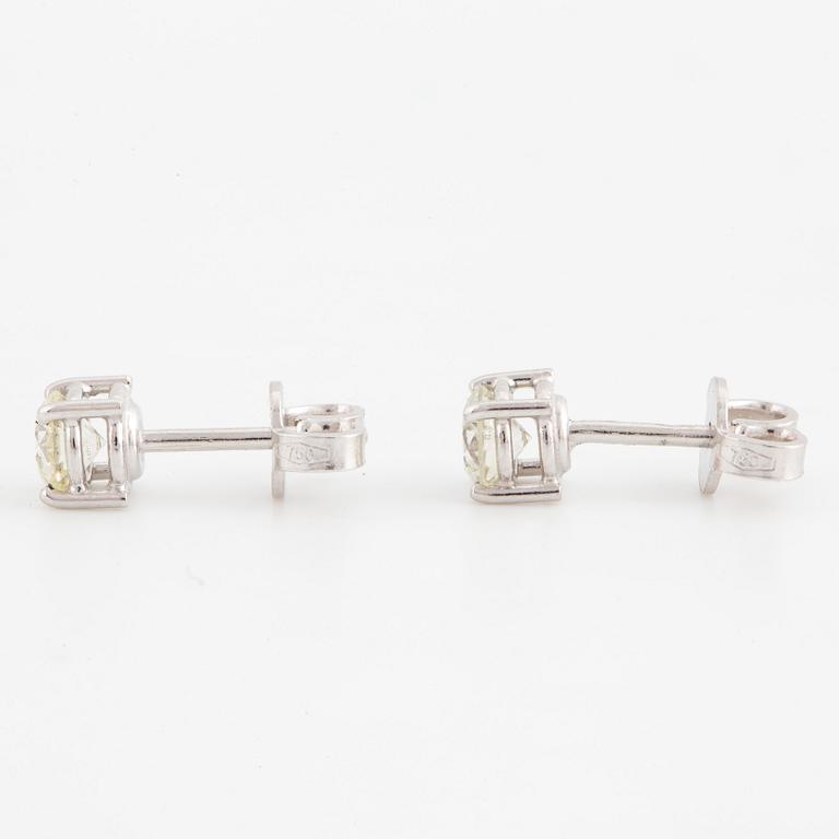 A pair of brilliant cut diamond earrings.