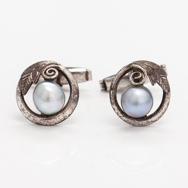 A pair of silver cufflinks with cultured baroque/Akoya pearls.