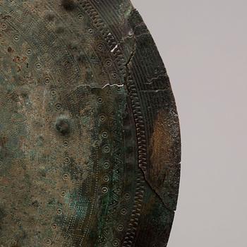 Three 20th century stone objects, with one bronze shield.