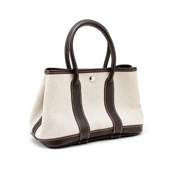 602. HERMÈS, a beige canvas and brown leather bag, "Garden Party".