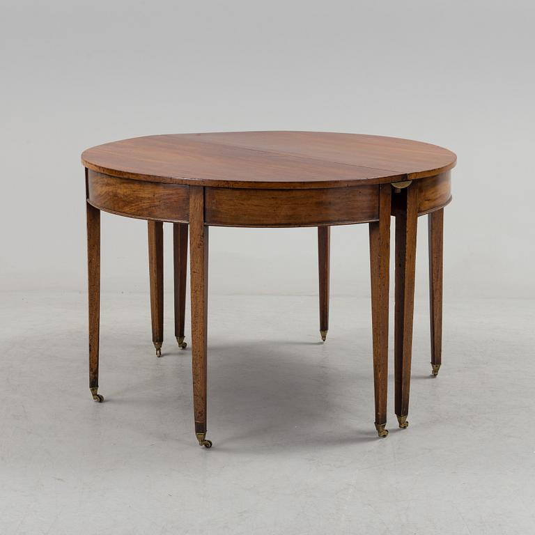 A English George III dining table veneerde with mahogany with two extension leafs from the late 18th century.