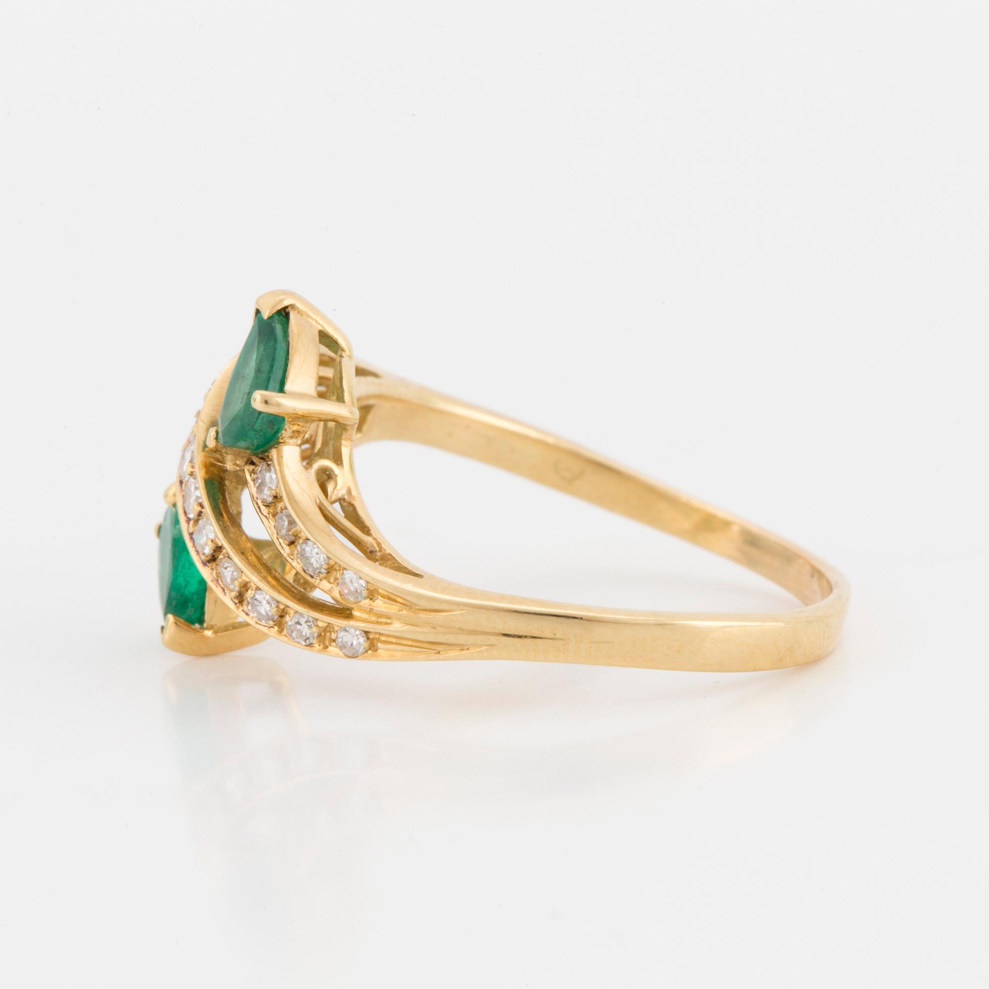 A ring set with pear-shaped emeralds and eight-cut diamonds.