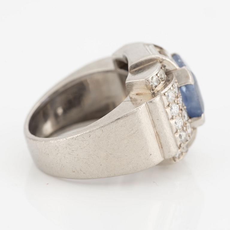 A platinum ring with a faceted sapphire and round brilliant-, eight-, and baguette-cut diamonds.