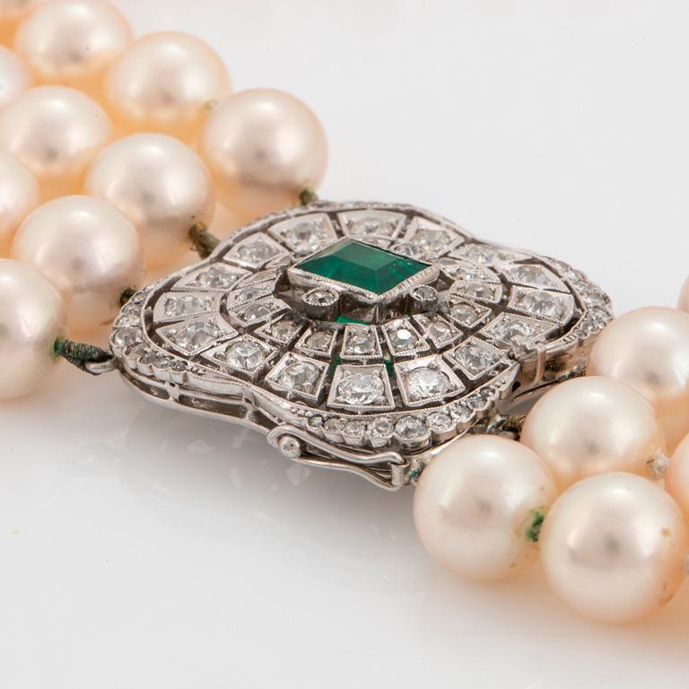 A four strand cultured pearl necklace with an 18K white gold clasp set with a faceted emerald.