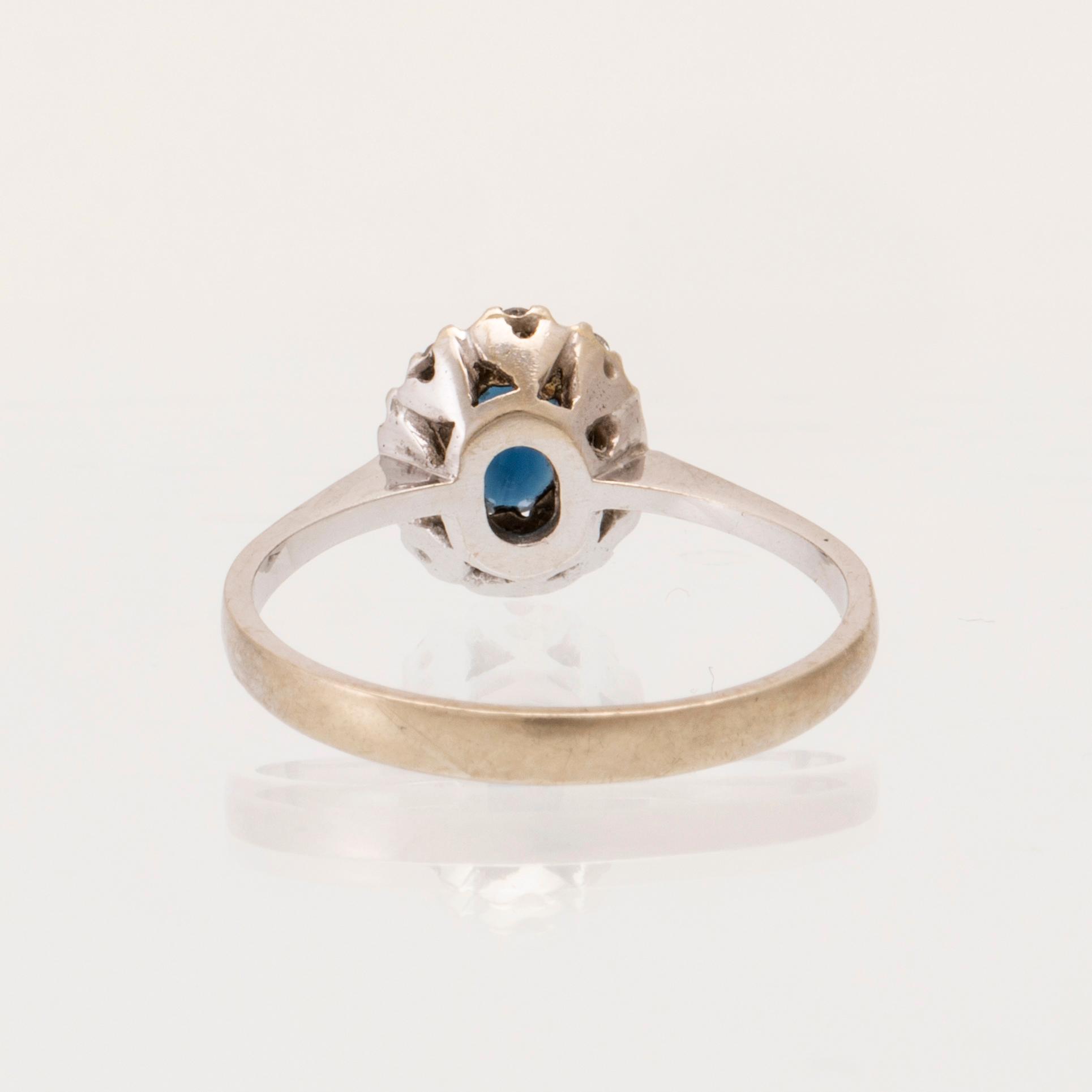 An 18K white gold carmosé ring set with an oval faceted sapphire and round brilliant-cut diamonds, Alessandria Italy.