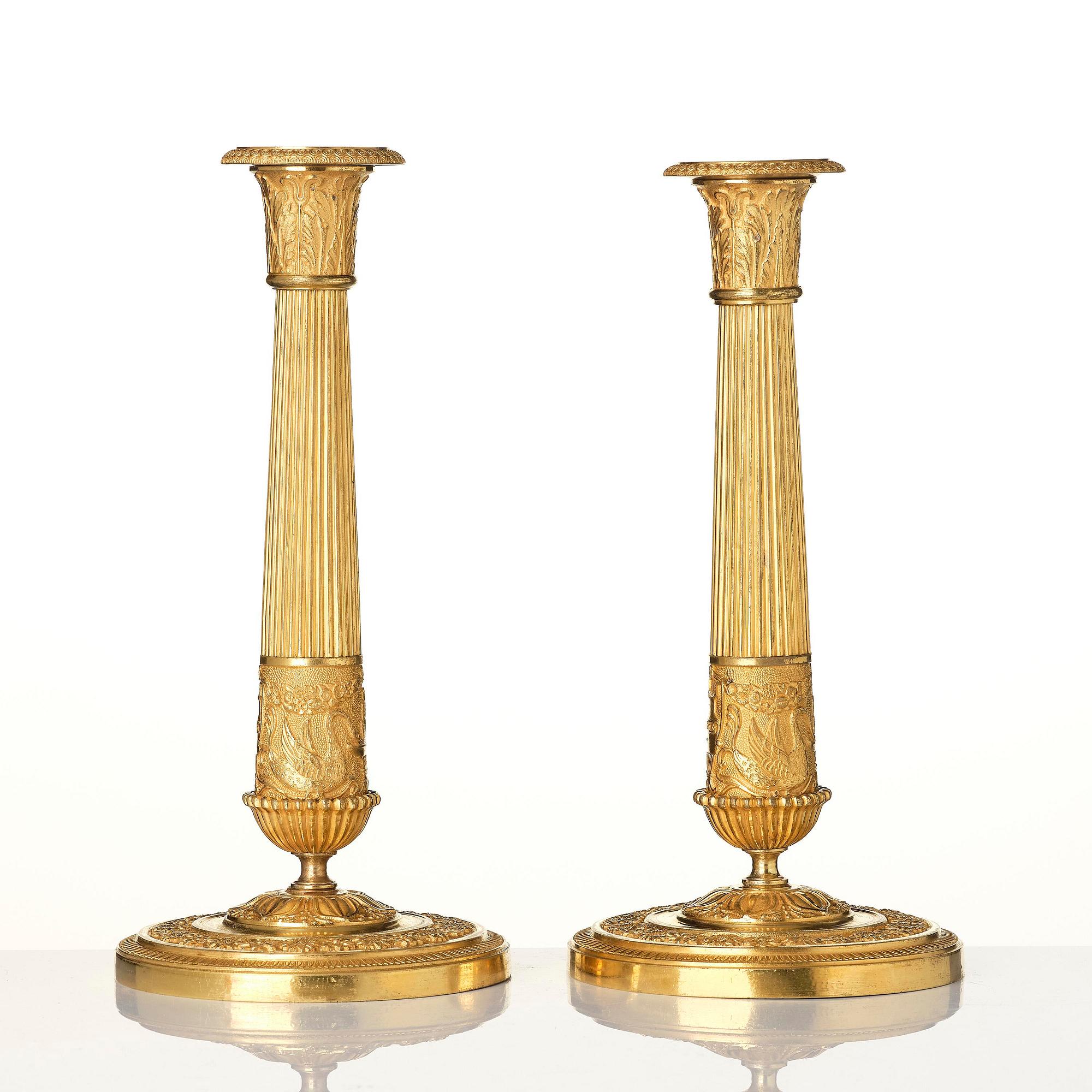 A pair of French Empire ormolu candlesticks, early 19th century.