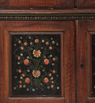 A Swedish polychrome painted folk art corner cabinet, dated 1818.