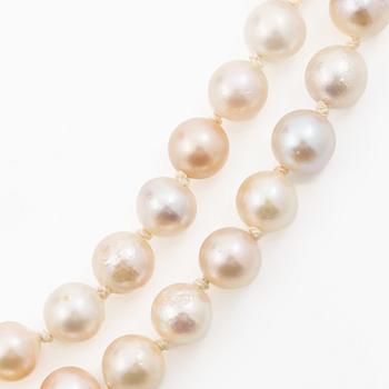 Long cultured pearl necklace with an 18K white gold clasp set with emeralds.