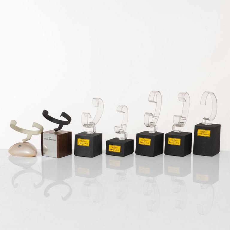 Clock stands, 7 pcs, Breitling, TAG Heuer and Girard-Perregaux.