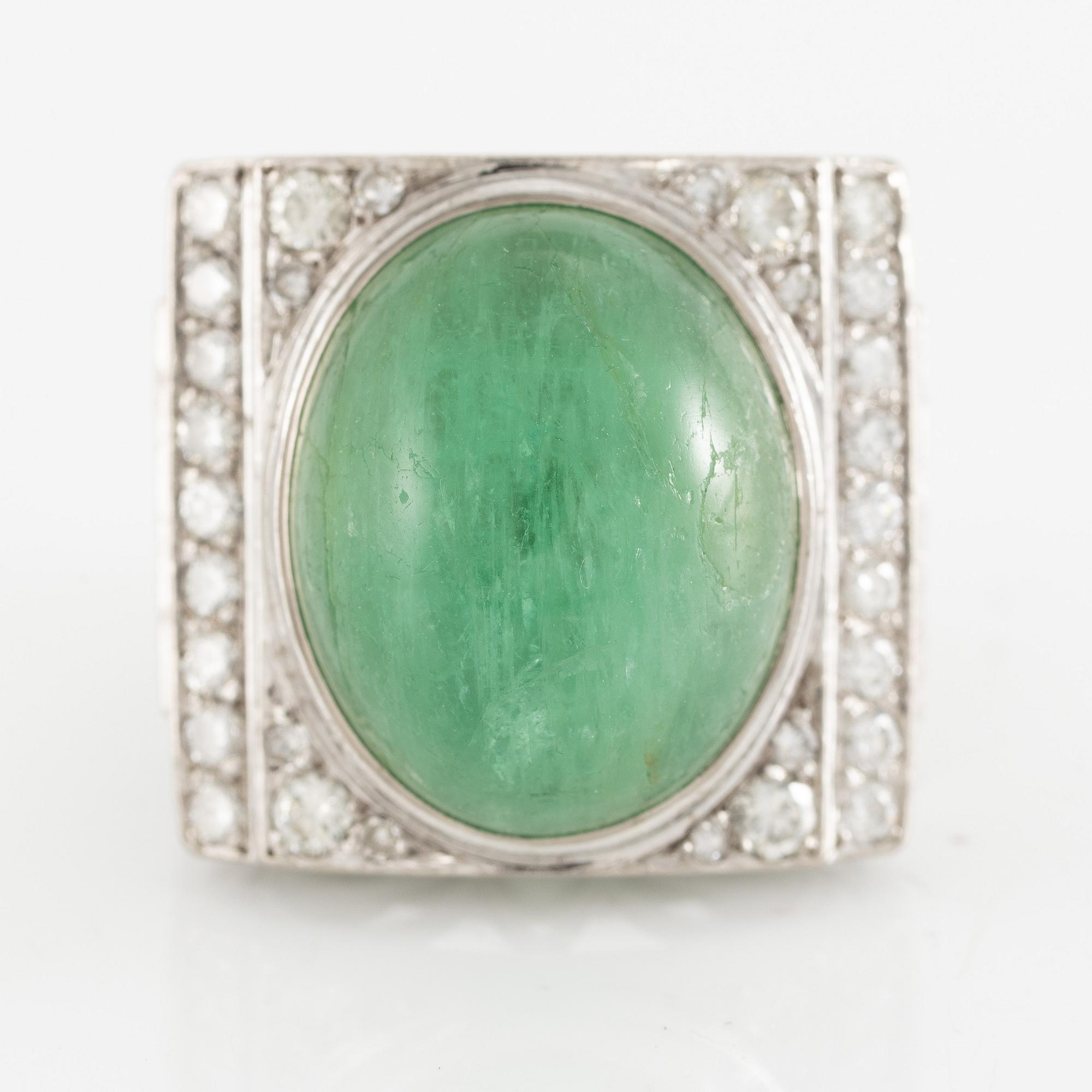 An 18K white gold ring set with a cabochon-cut emerald and round- and eight-cut diamonds.