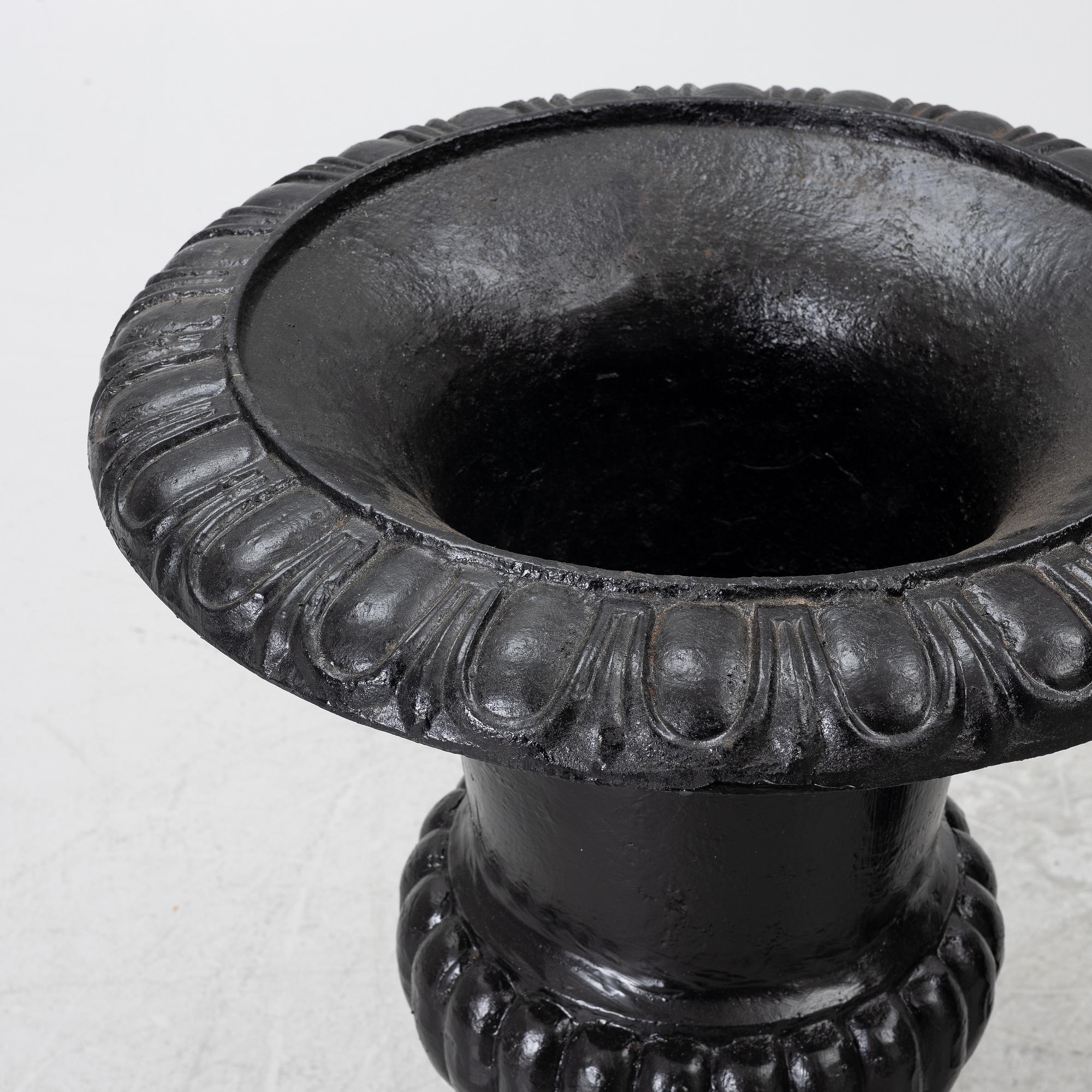 A pair of cast iron garden urns, 20th century.