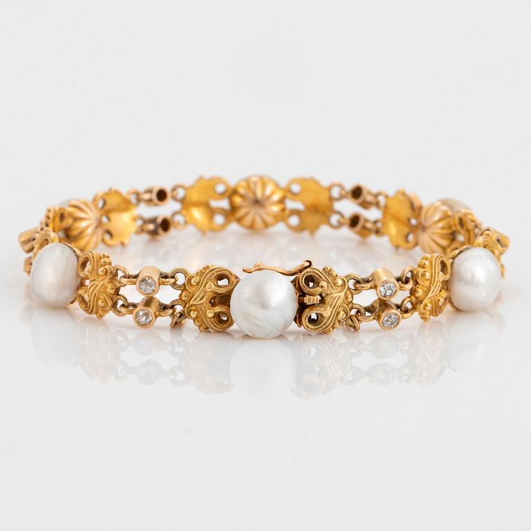 A 14K gold bracelet set with pearls, possibly natural, and old-cut diamonds.