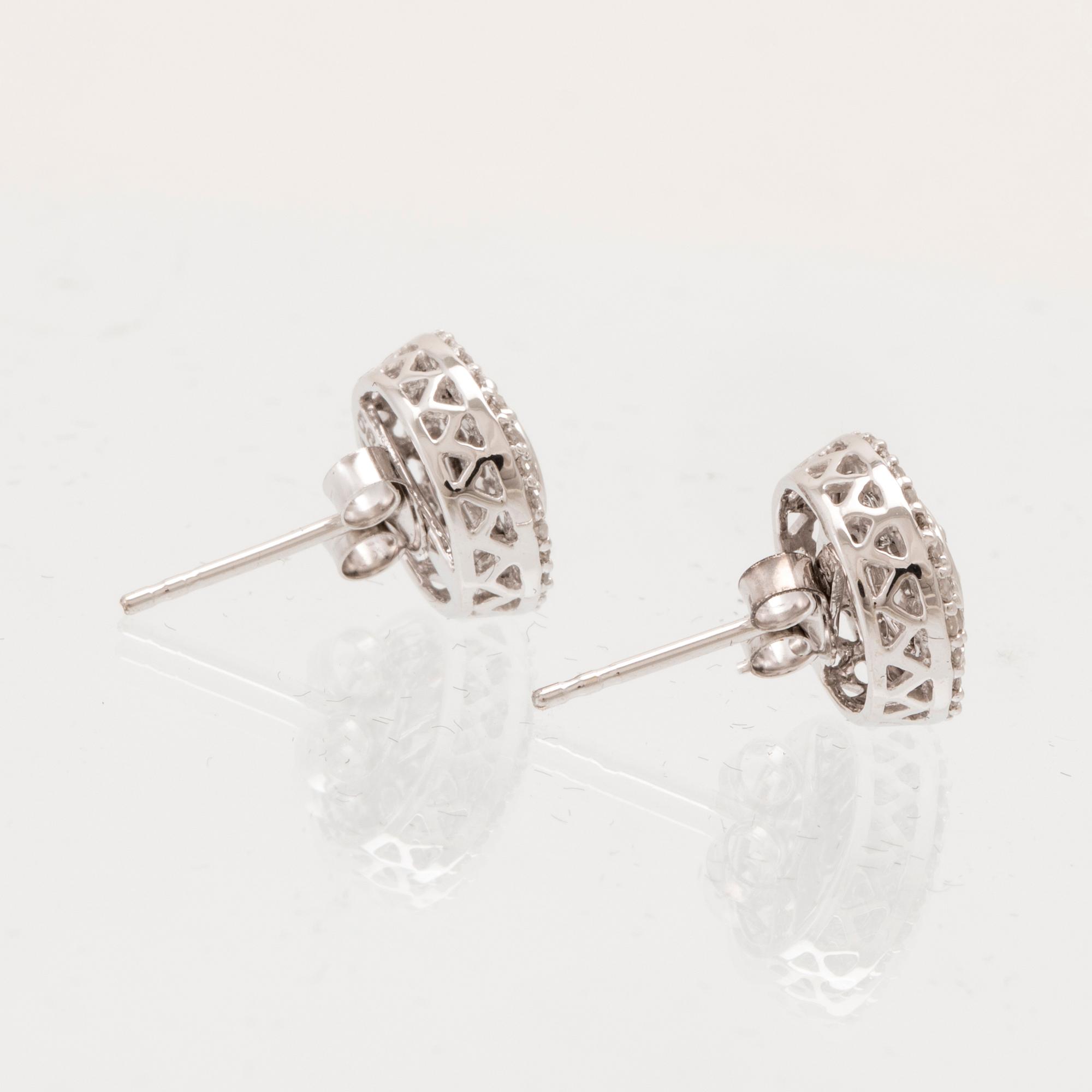 A pair of 14K white gold earrings set with round single-cut diamonds.