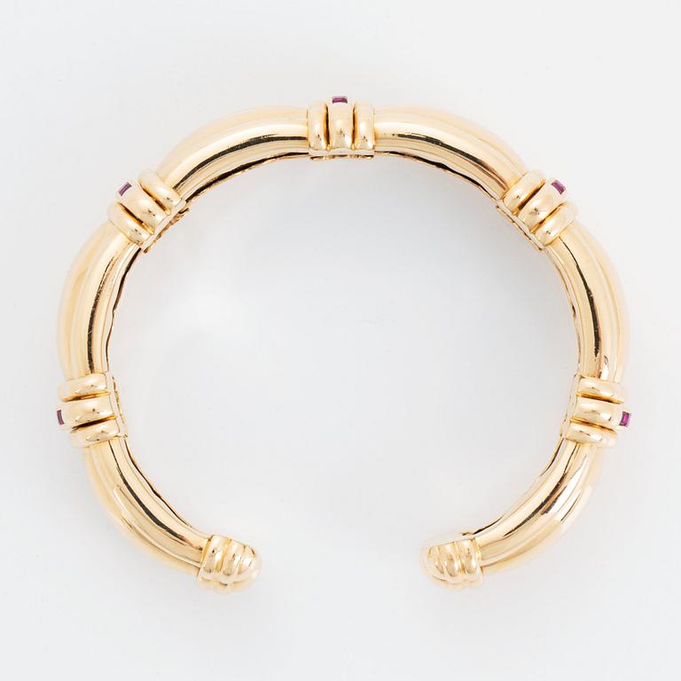 An 18K gold bracelet set with step-cut rubies.