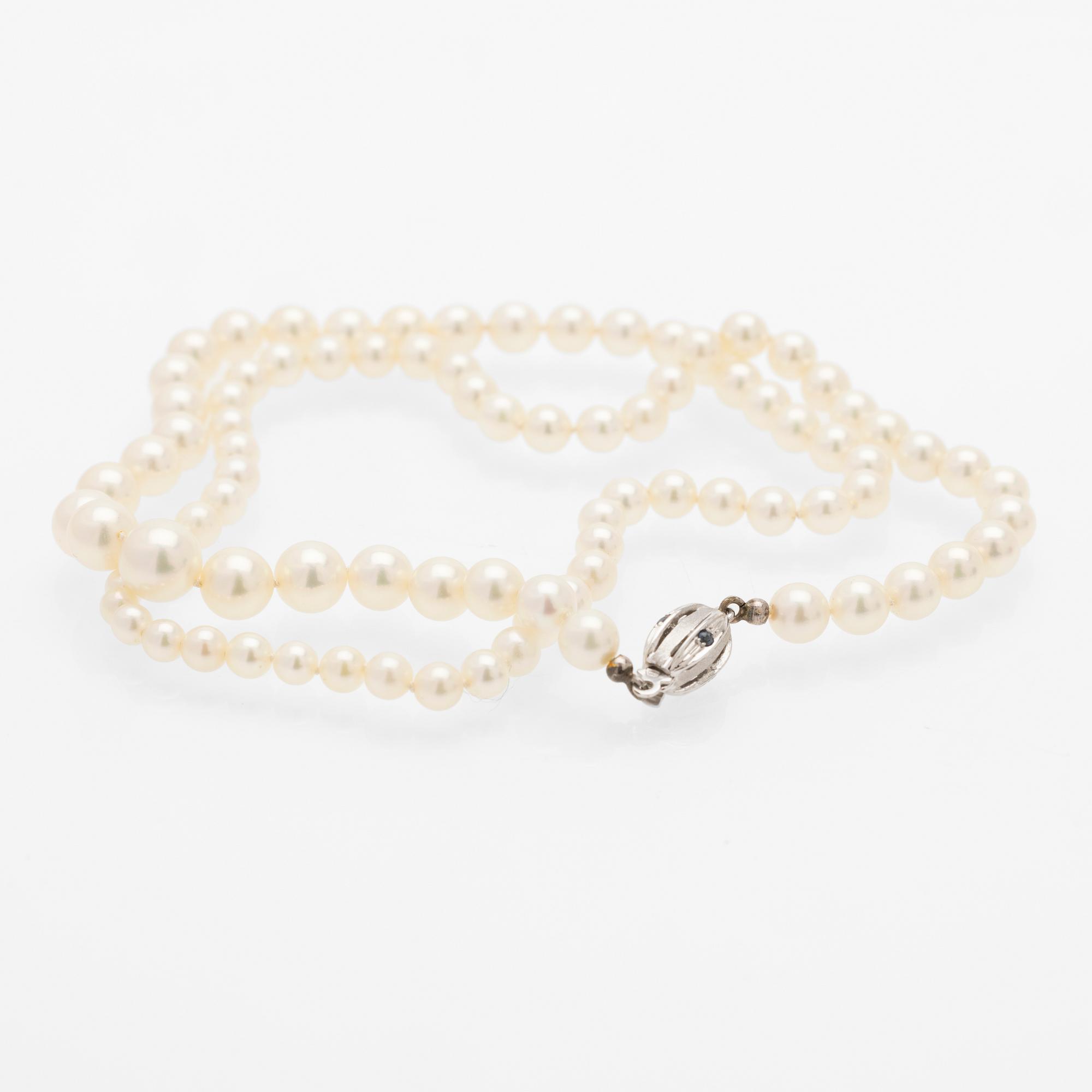 Necklace of cultured graduated pearls with an 18K white gold and sapphire clasp.