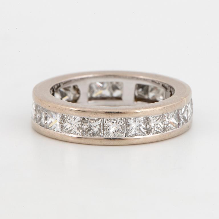 An 18K white gold eternity ring set with princess-cut diamonds.