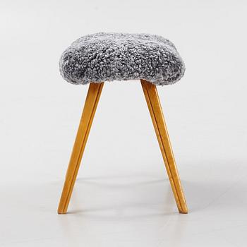 A birch stool with new sheepskin upholstery.