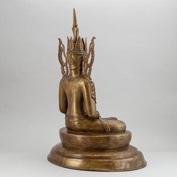 A seated buddha, yellow metal, possibly Nepal, 20th century.