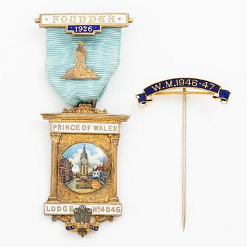 A jeton and pin, in gilded silver and 9 ct gold respectively.