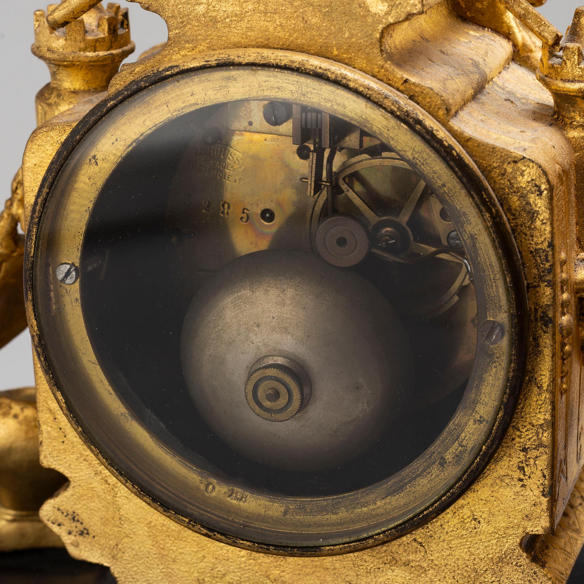 A late 19th century table clock and a pair of candlesticks.