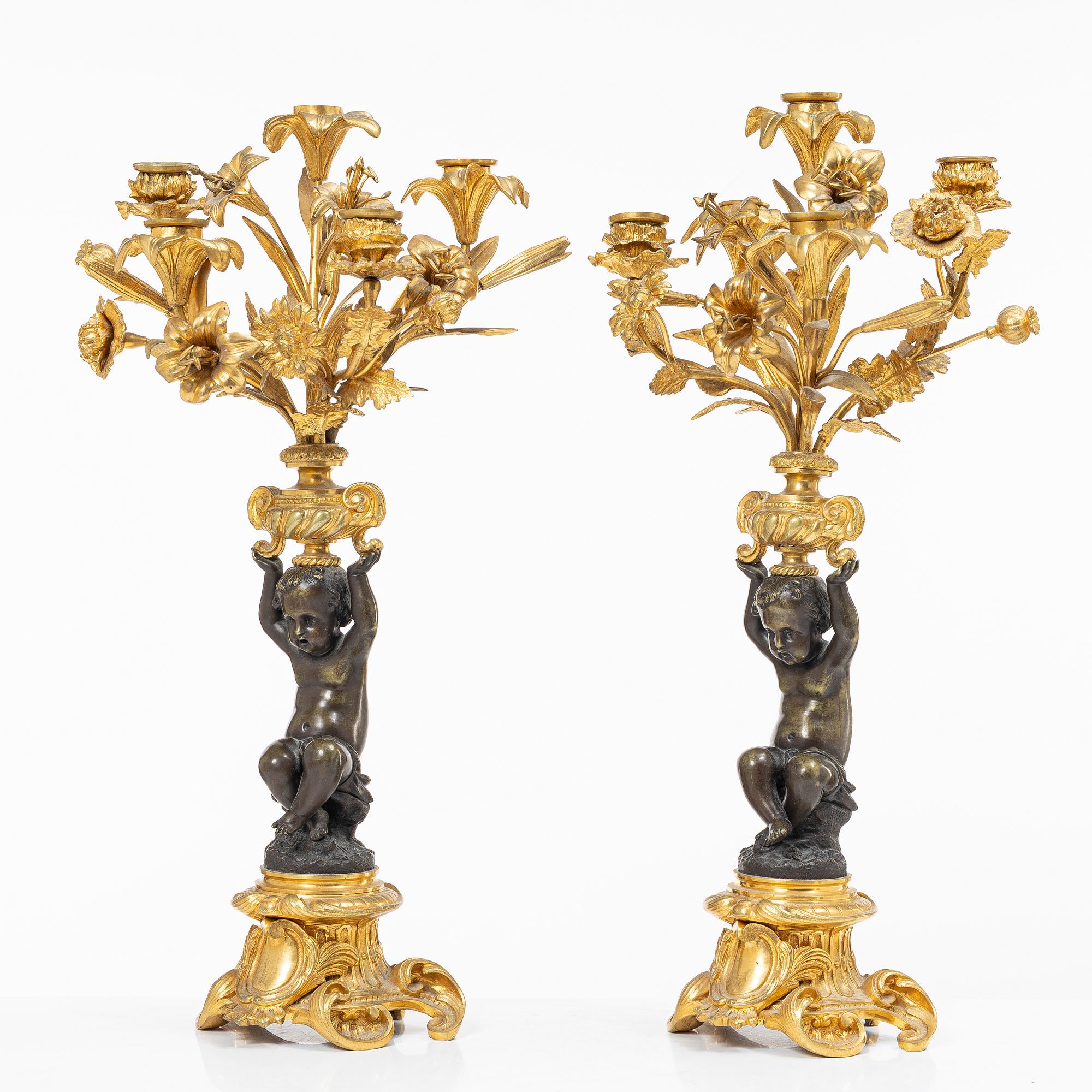 A Rococo style mantle clock and pair of candelabra, France, late 19th Century.