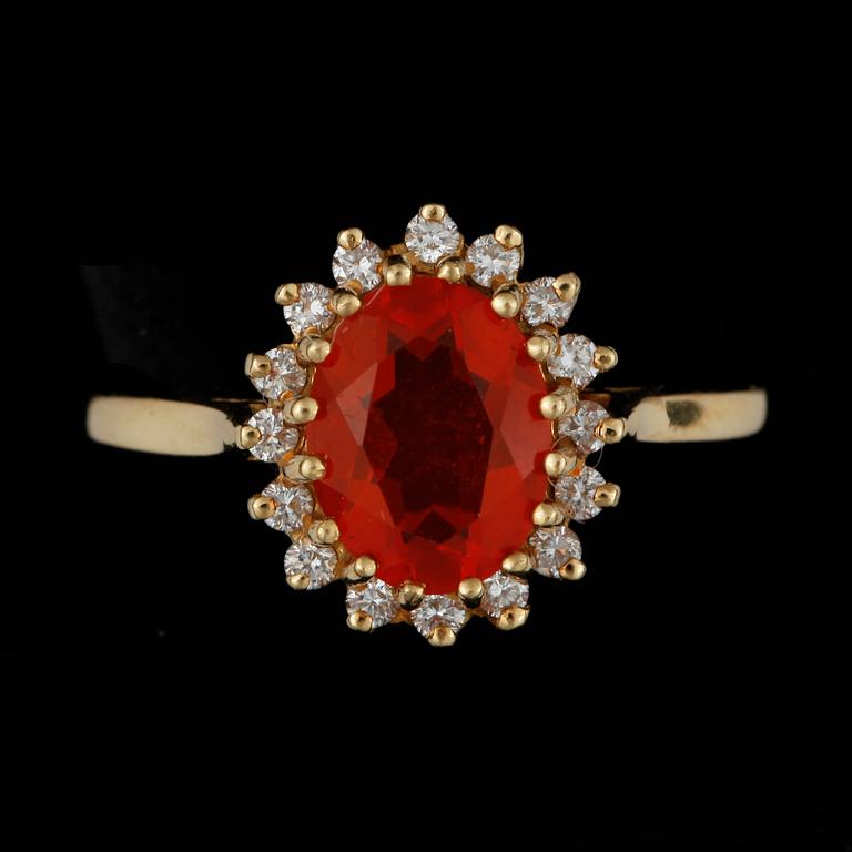 RING, 18k guld med eldopal och krans av 16 små briljantslipade diamanter, tot ca 0,16 ct. Vikt ca 4 gram.