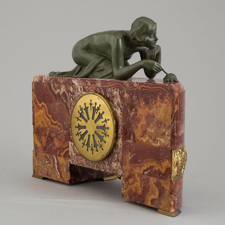 An early 20th century mantle clock with a bronze sculpture signed M. Charny.