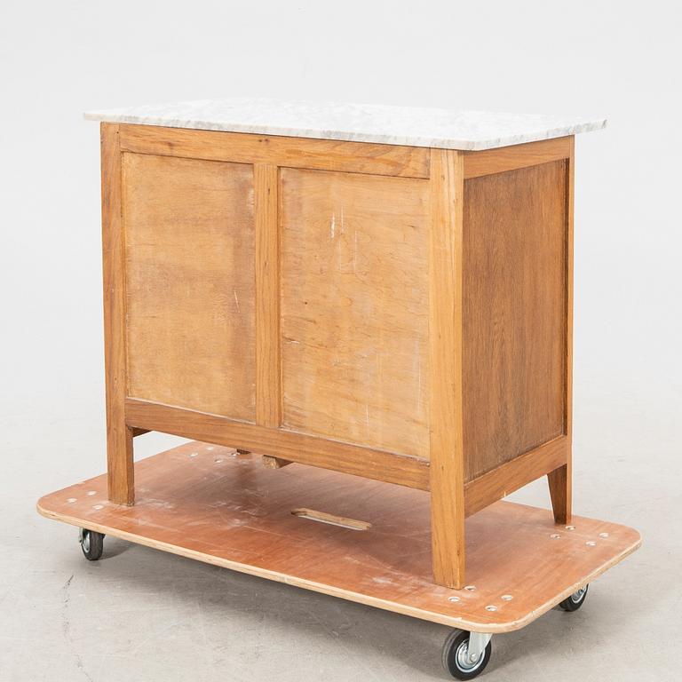 An early 1900s oak and marble cabinet.