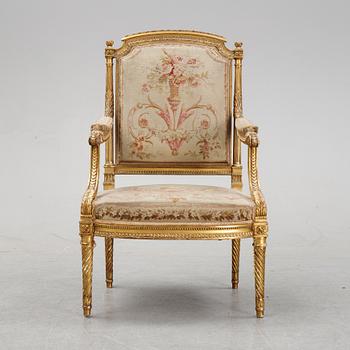 A gilt Louis XVI style armchair from around the year 1900.