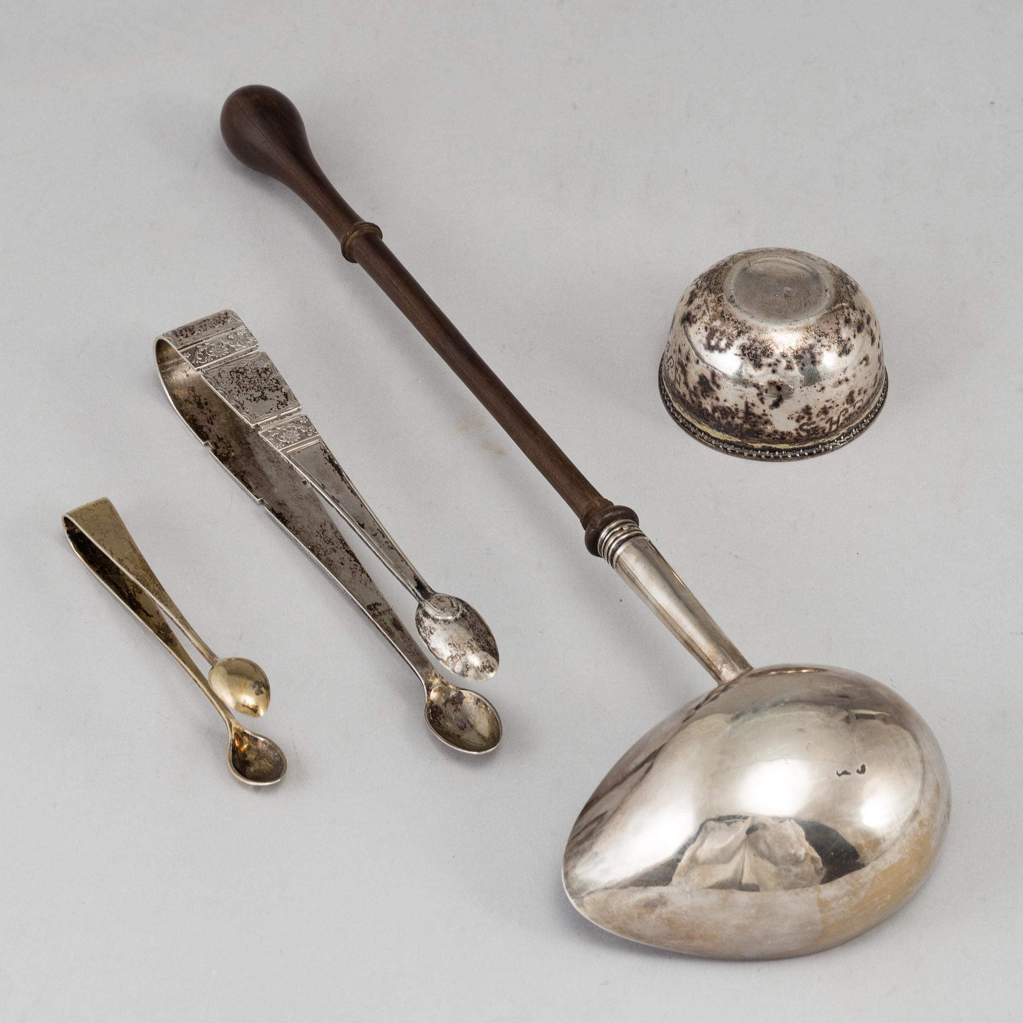 An English 18th century silver ladle, a silver tumbler and two silver sugar-tongs.