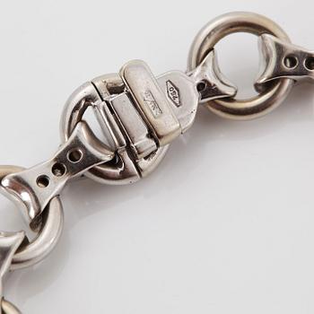 An 18K white gold bracelet set with round brilliant-cut diamonds.