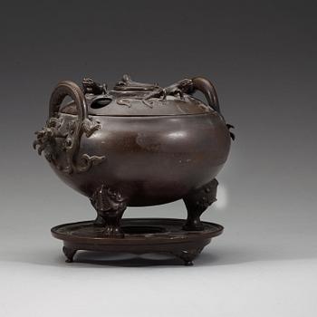 A bronze tripod censer with cover and stand, Qing dynasty, 17/18th Century.