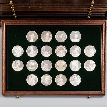 100 sterling silver coins in a wooden cabinet by Franklin Mint.