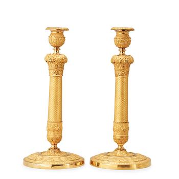 1461. A pair of French Empire early 19th cenury gilt bronze candlesticks.
