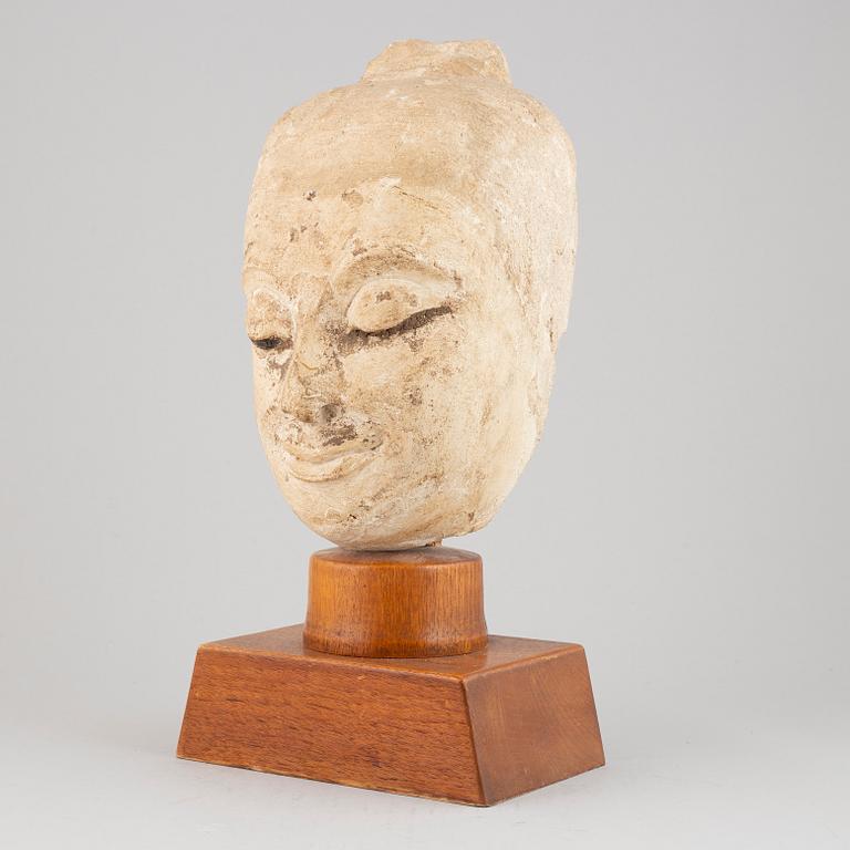 A South East Asian stone mass sculpture of a head, presumably modern manufacturing.