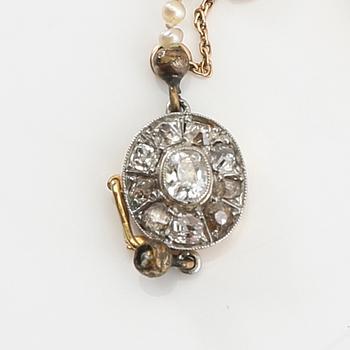 Necklace of cultured pearls with a clasp of gold set with diamonds.