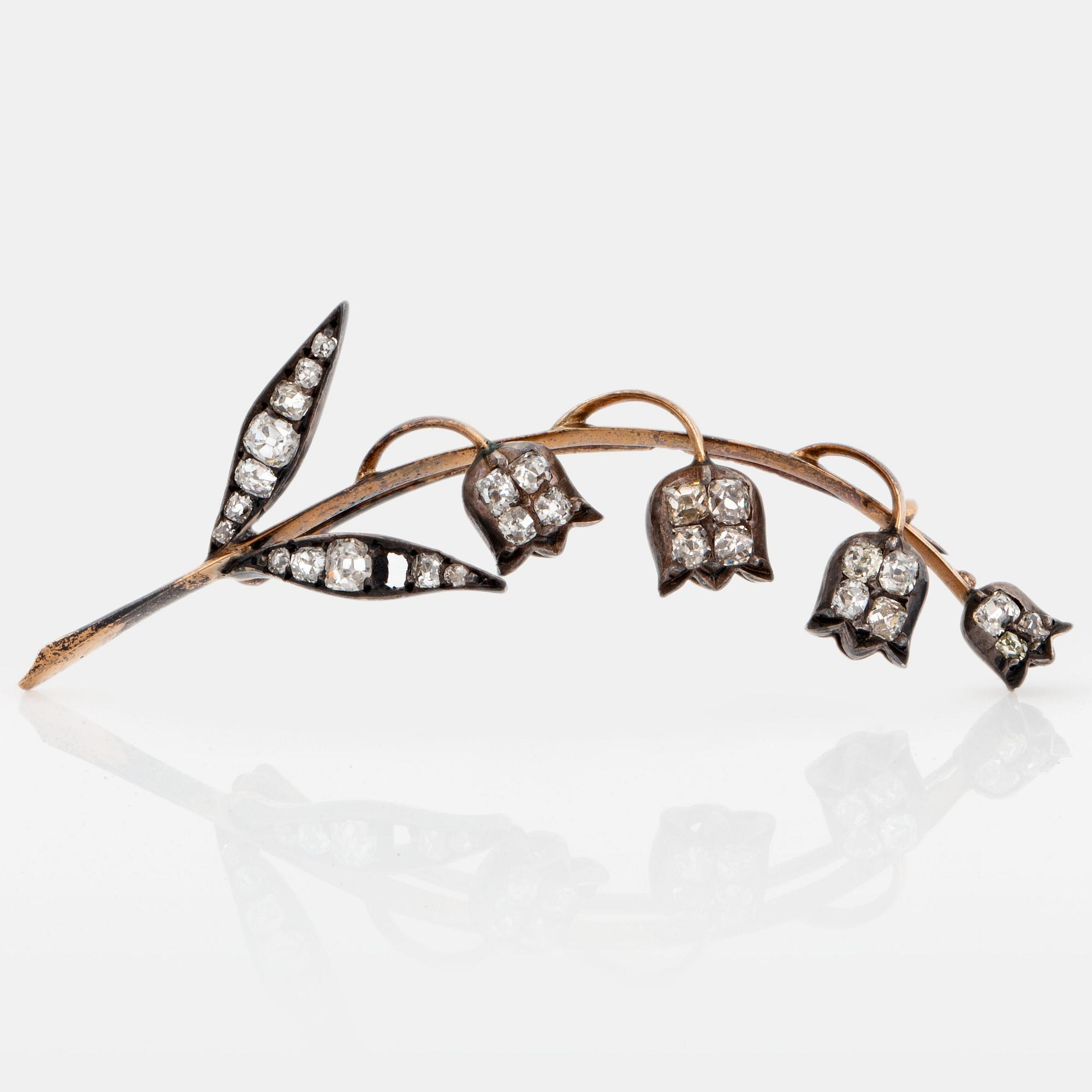 A brooch in 14K gold and silver set with old-cut diamonds, in the shape of a lily-of-the valley twig.