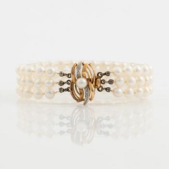 Bracelet, three-stranded with cultured pearls, clasp with a pearl and small diamonds.