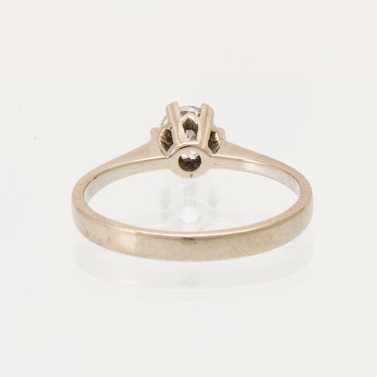 An 18K white gold solitaire ring set with a round brilliant-cut diamond.