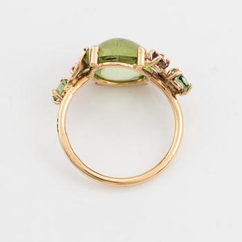 Ring with cabochon-cut peridot, tourmaline, and small diamonds.