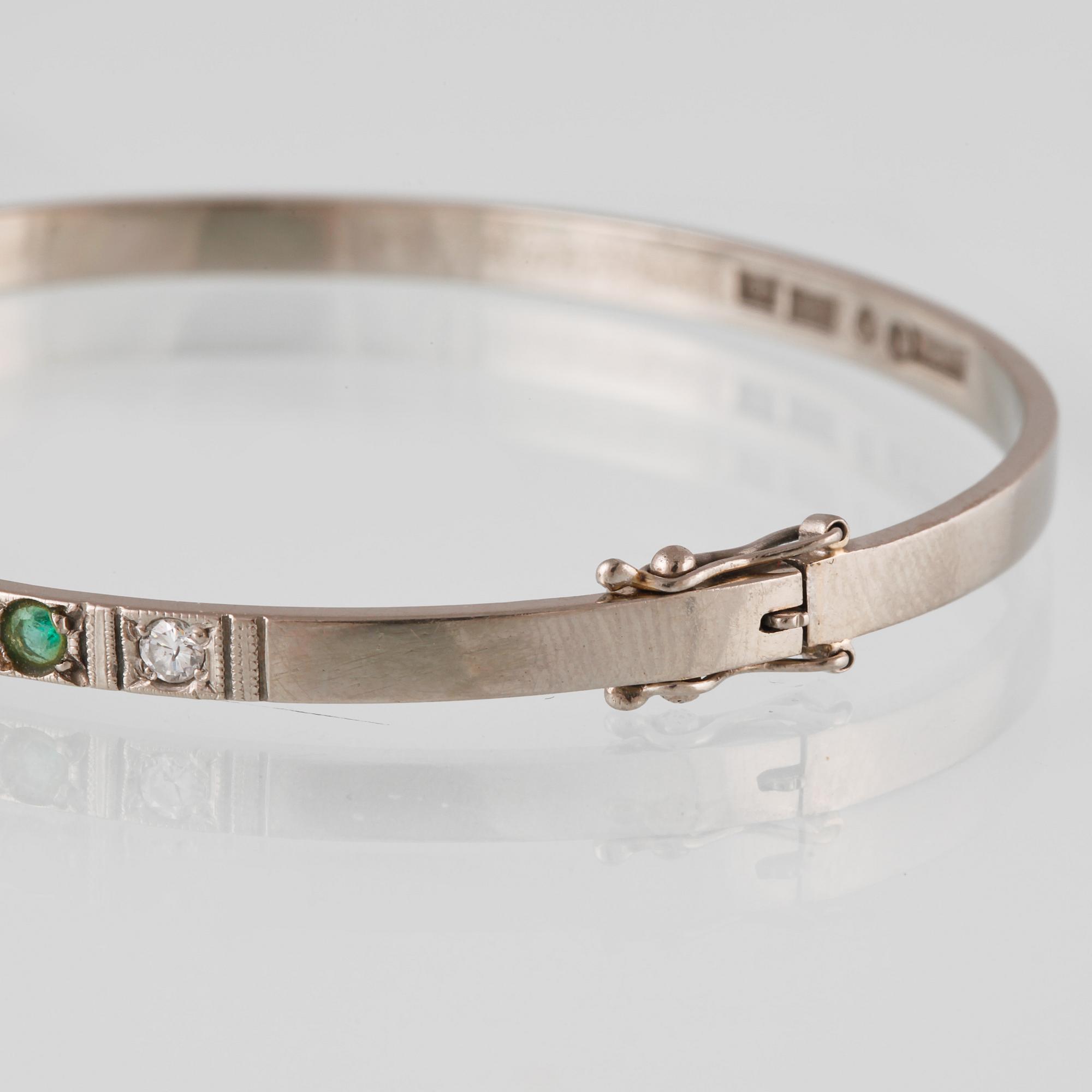 ARMRING, 18k vitguld med 5 briljantslipade diamanter och 4 smaragder, Sten Gramen, Göteborg, 1965. Vikt 13,3 gram.