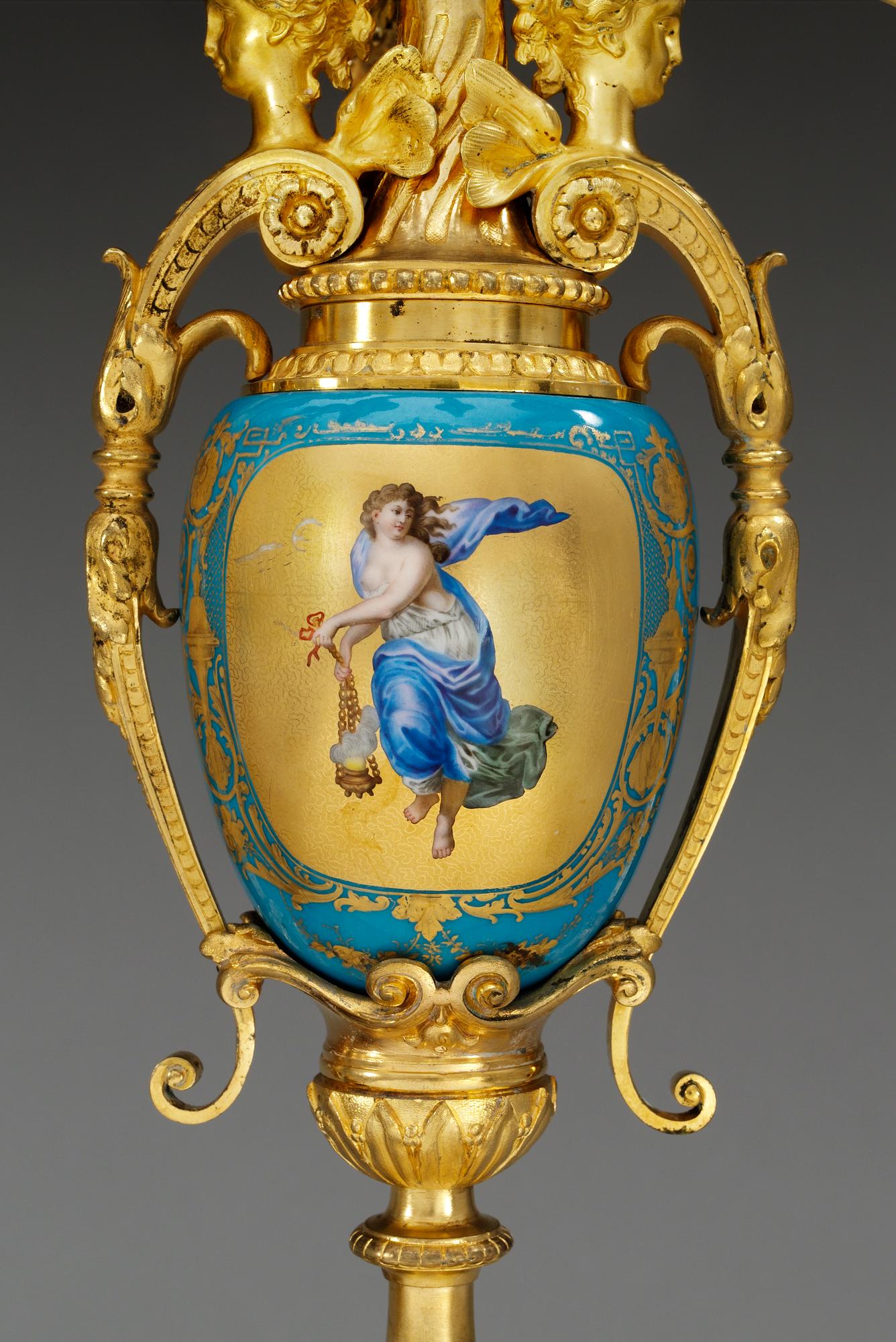 A pair of seven-light gilt bronze chandelabras with porcelain settings, 19th Century, presumably Russian.