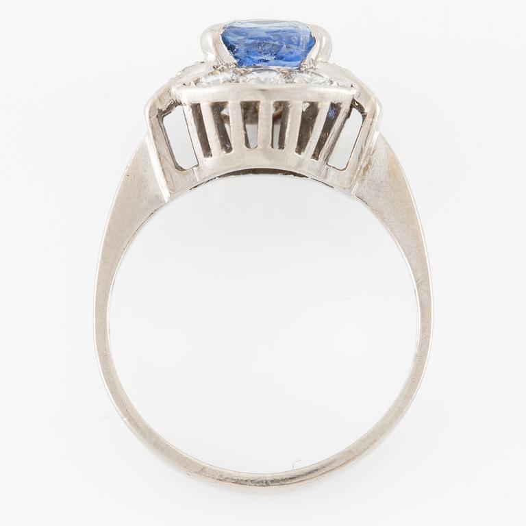 Ring 18K white gold set with a faceted sapphire and round brilliant-cut diamonds.