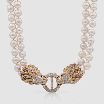 1359. A 2-strand semi-baroque cultured pearl necklace. Clasp in the shape of two lionheads covered in brilliant-cut diamonds.
