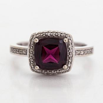 A 14K gold ring, with diamonds totalling approximately 0.095 ct and a garnet.