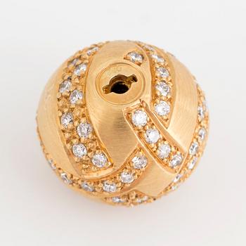 An 18K gold clasp set with round brilliant-cut diamonds.